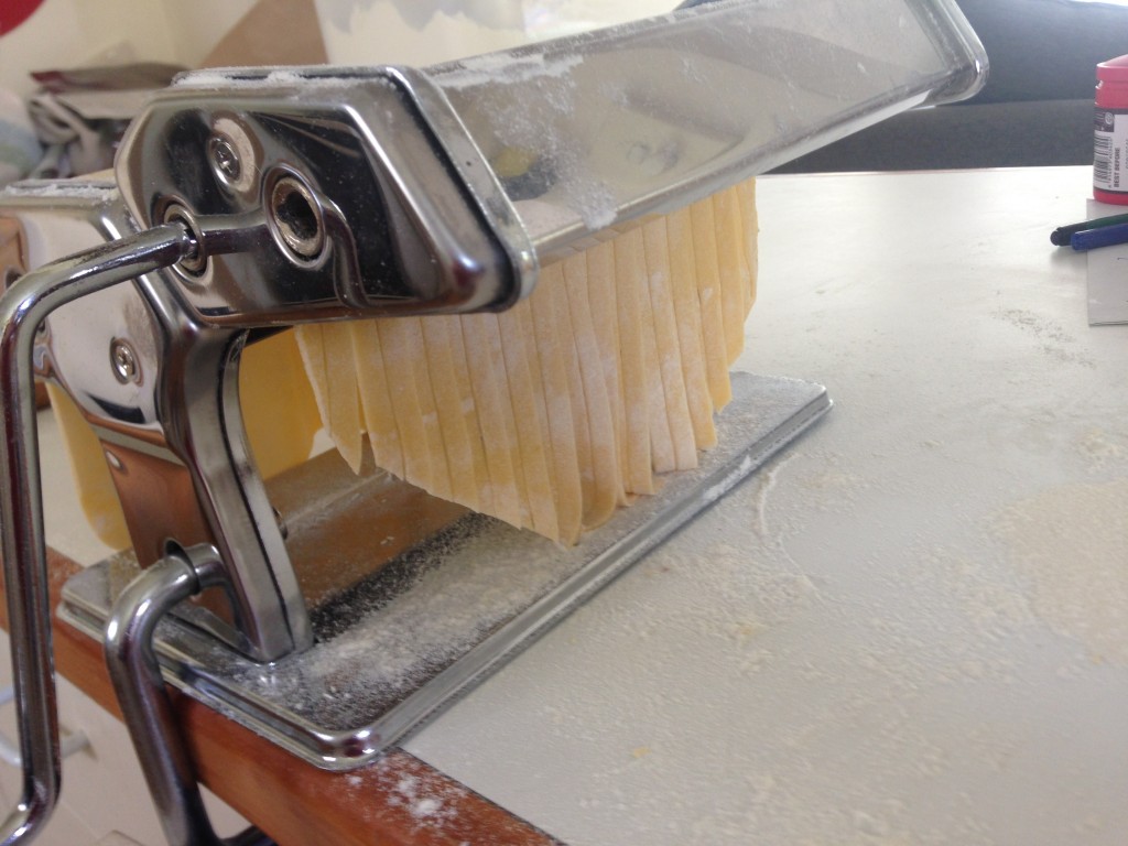 Cutting a rolled past sheet into fettucine.